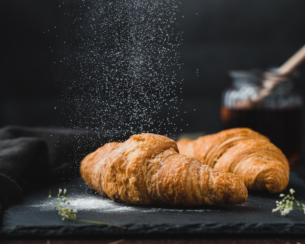 Two flaky butter croissants with a light dusting of sugar